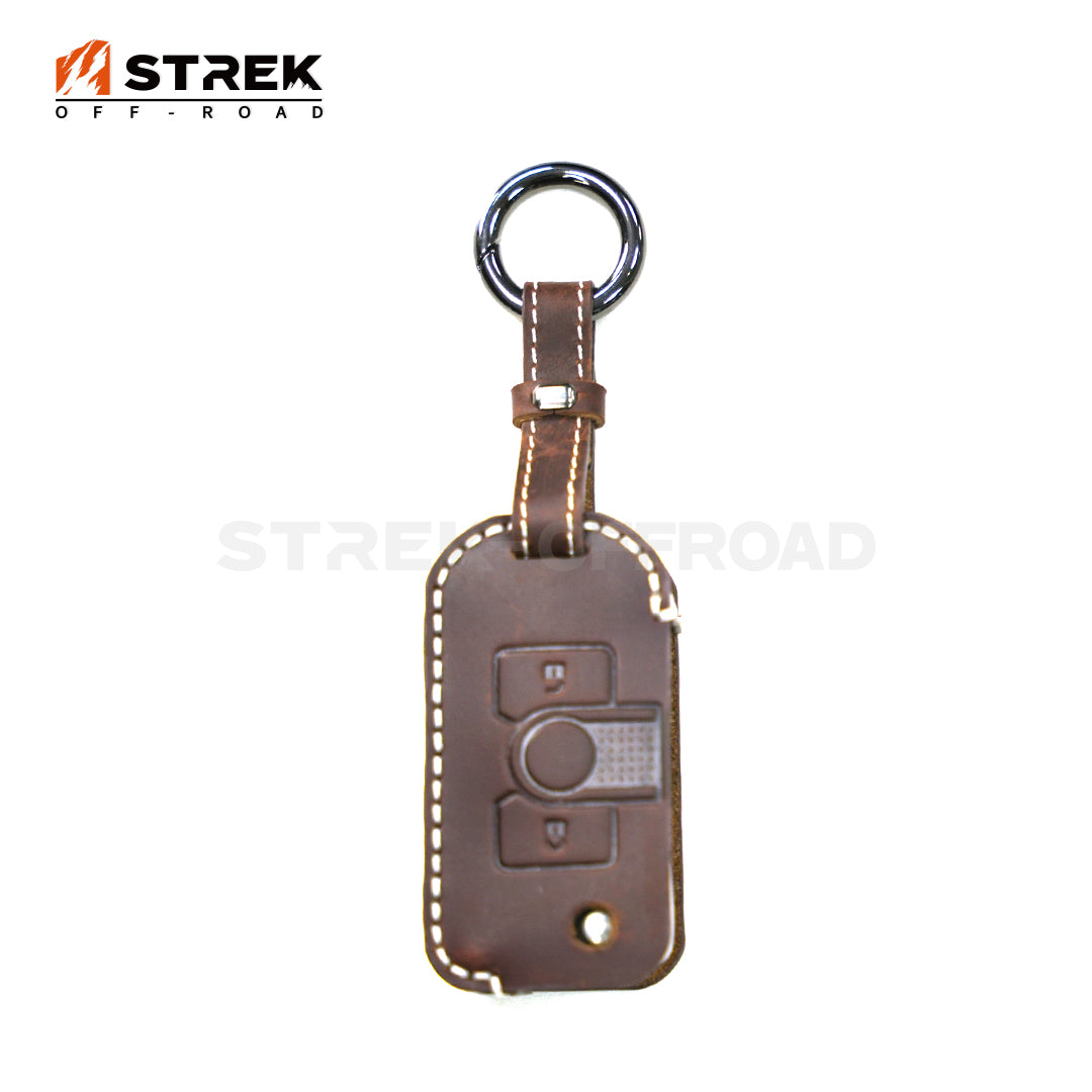 Brown leather key fob cover with car key symbol on a white background, featuring the STREK OFF-ROAD logo.