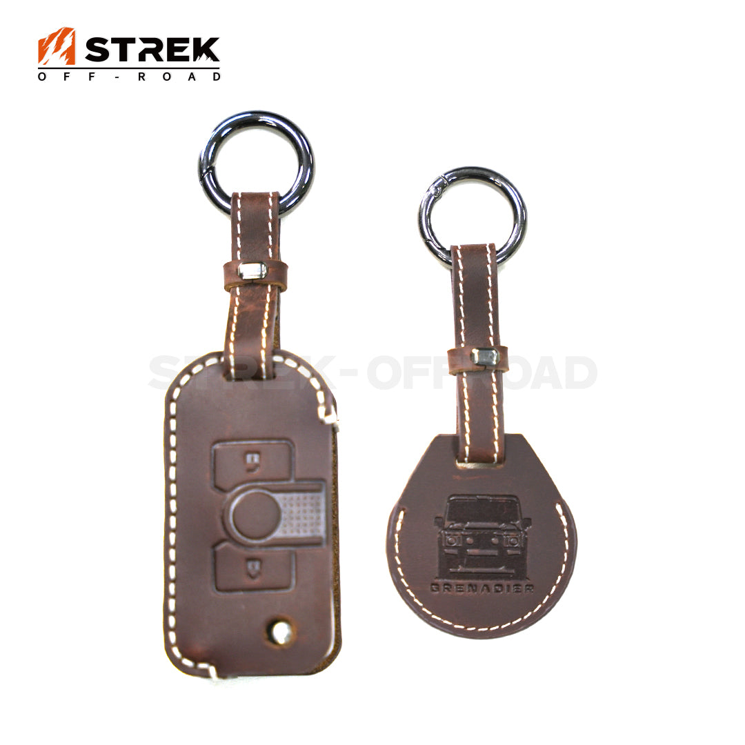 Two brown leather key fobs with a visible brand logo on a white background