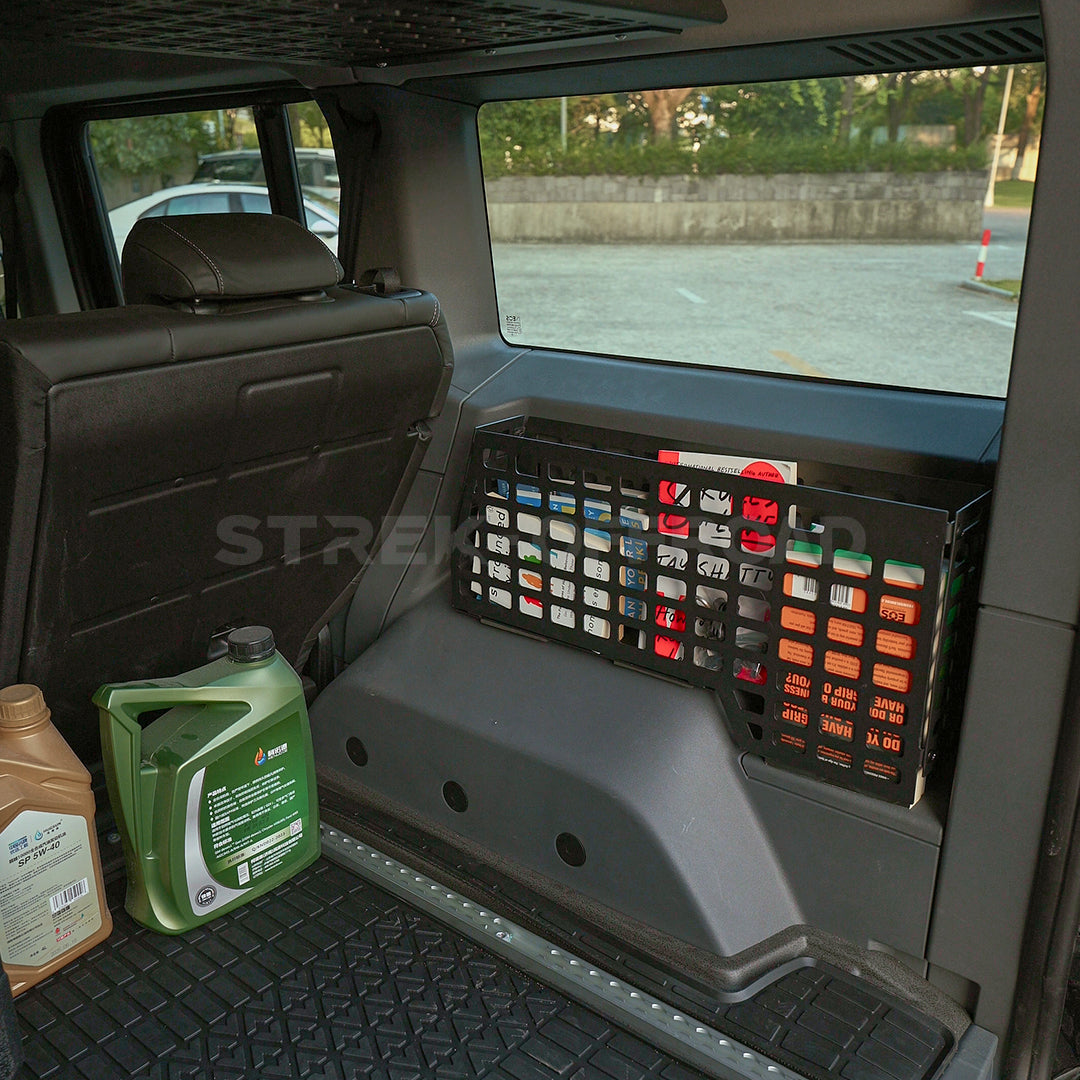 Car interior with a storage tray and oil containers on a black mat.