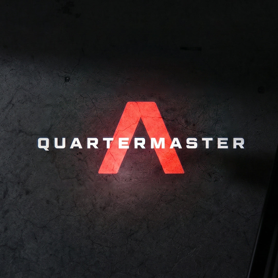 Illuminated red chevron graphic and white Quartermaster text projected on the ground from the LED puddle light.