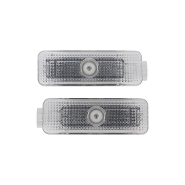 Pair of direct-fit LED puddle lamp replacement modules showing front optical projector lenses on a white background.