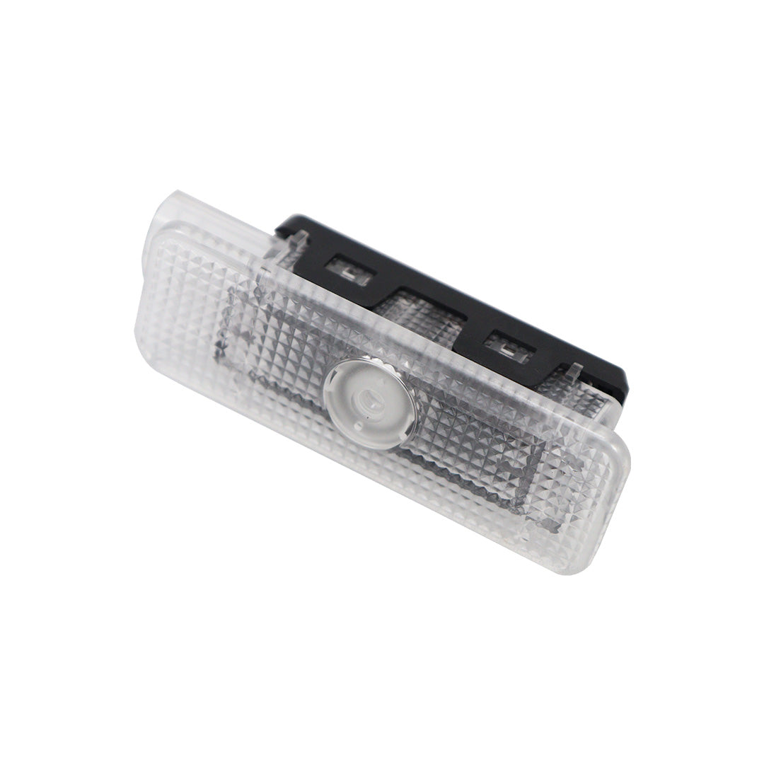 Angled view of a single LED puddle light module displaying the transparent lens surface and central projector.
