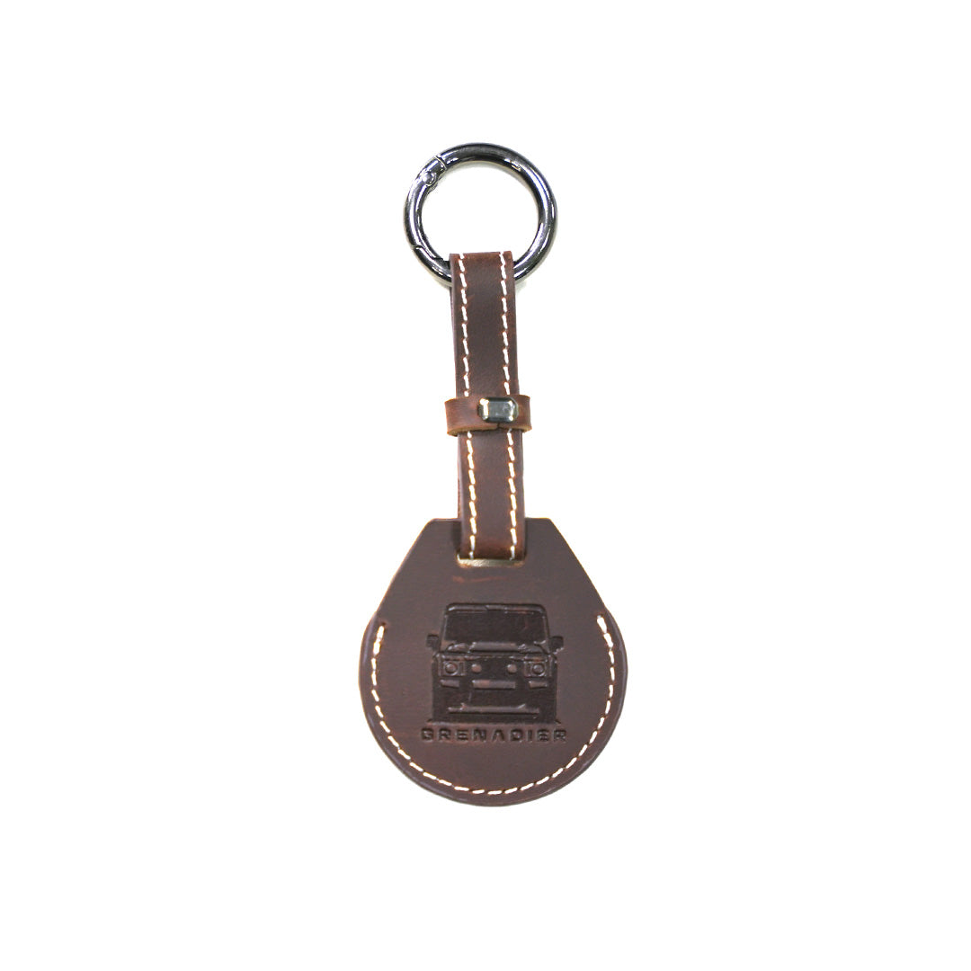Brown leather AirTag holder loop keychain featuring a detailed vehicle graphic debossing compatible with INEOS Grenadier cabin styling.