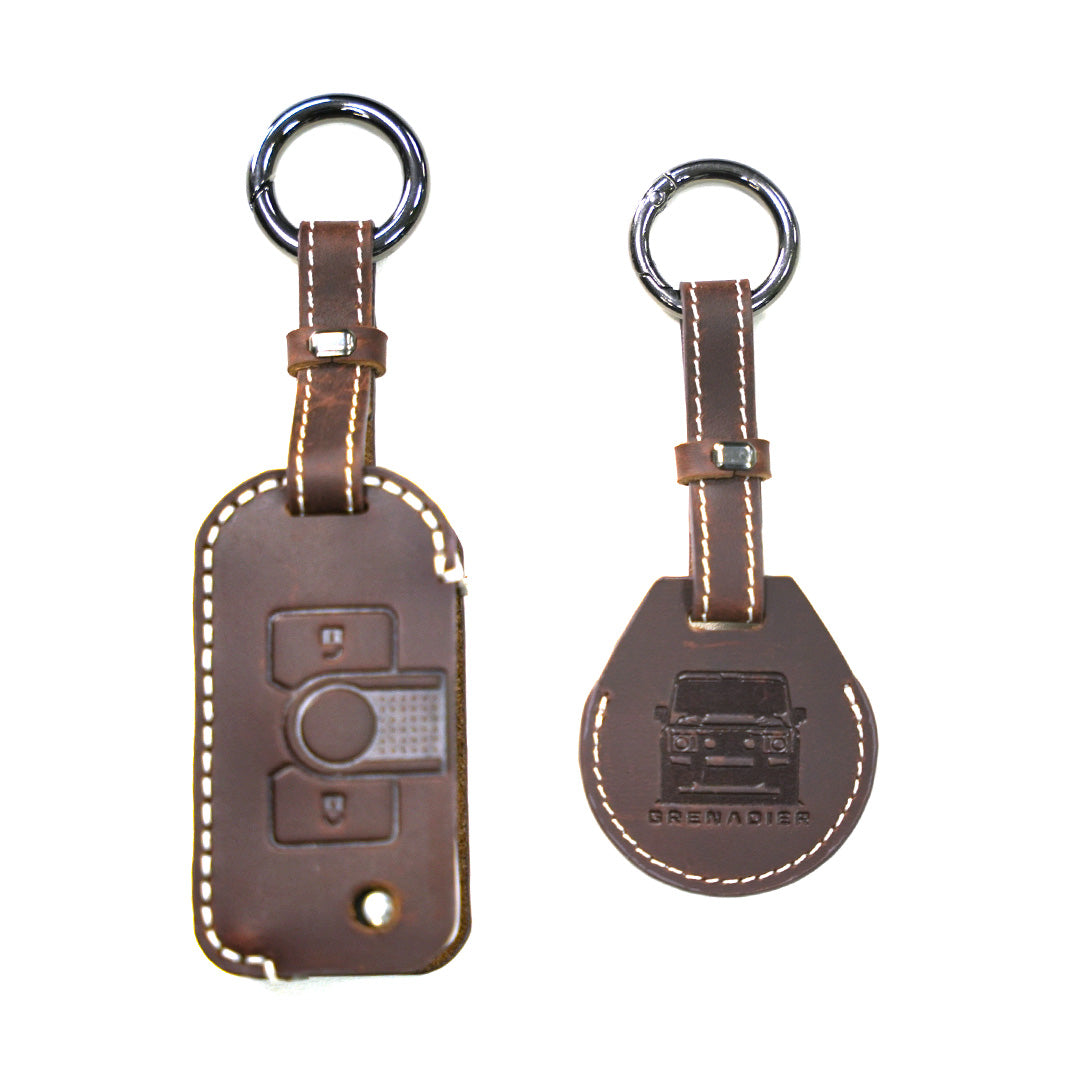 STREK Off Road brown leather key fob sleeve and AirTag holder combo set designed for INEOS Grenadier accessories, equipped with a dark metallic attachment ring.