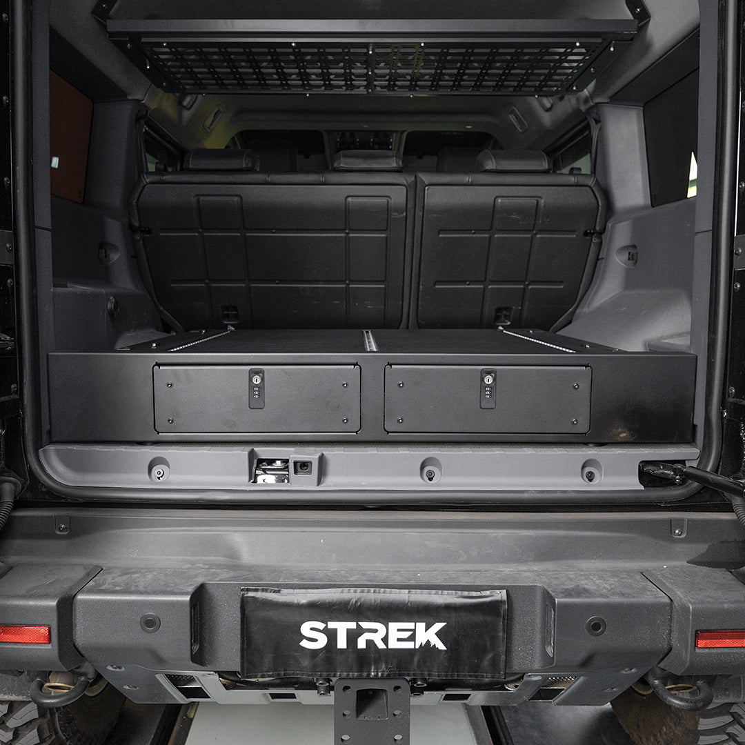 STREK Offroad Twin Drawer System for Ineos Grenadier with 32L lockable cargo storage and key-lock drawer fronts installed in the rear cargo area.