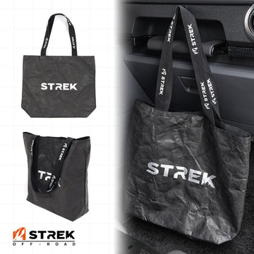 STREK Overland Tyvek Utility Tote Bag shown in a branded overview with product views and an INEOS Grenadier interior use scene.