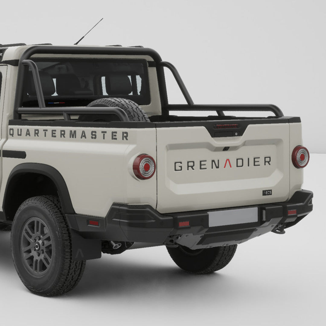 Tailgate inlay decals installed on the rear tailgate of a white INEOS Grenadier Quartermaster pickup.