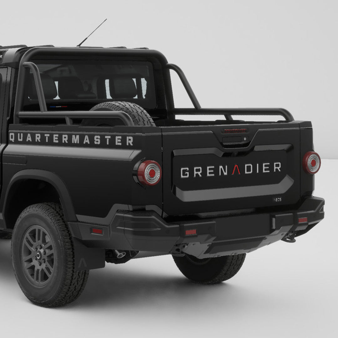 Tailgate inlay decals installed on the rear tailgate of a black INEOS Grenadier Quartermaster pickup.