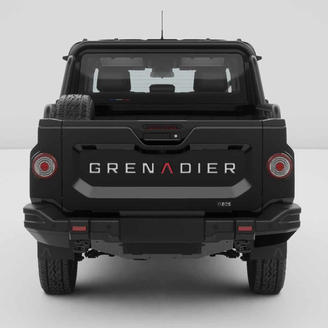 Straight rear view of a black INEOS Grenadier Quartermaster with GRENADIER tailgate inlay decals installed.