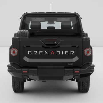 Straight rear view of a black INEOS Grenadier Quartermaster with GRENADIER tailgate inlay decals installed.